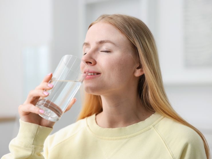 donna che beve un bicchiere d'acqua