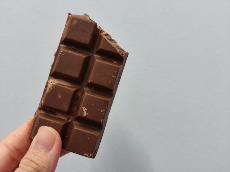 mano che mantiene una tavoletta di cioccolato