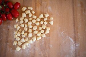 gnocchi freschi e pomodorini poggiati su un tagliere