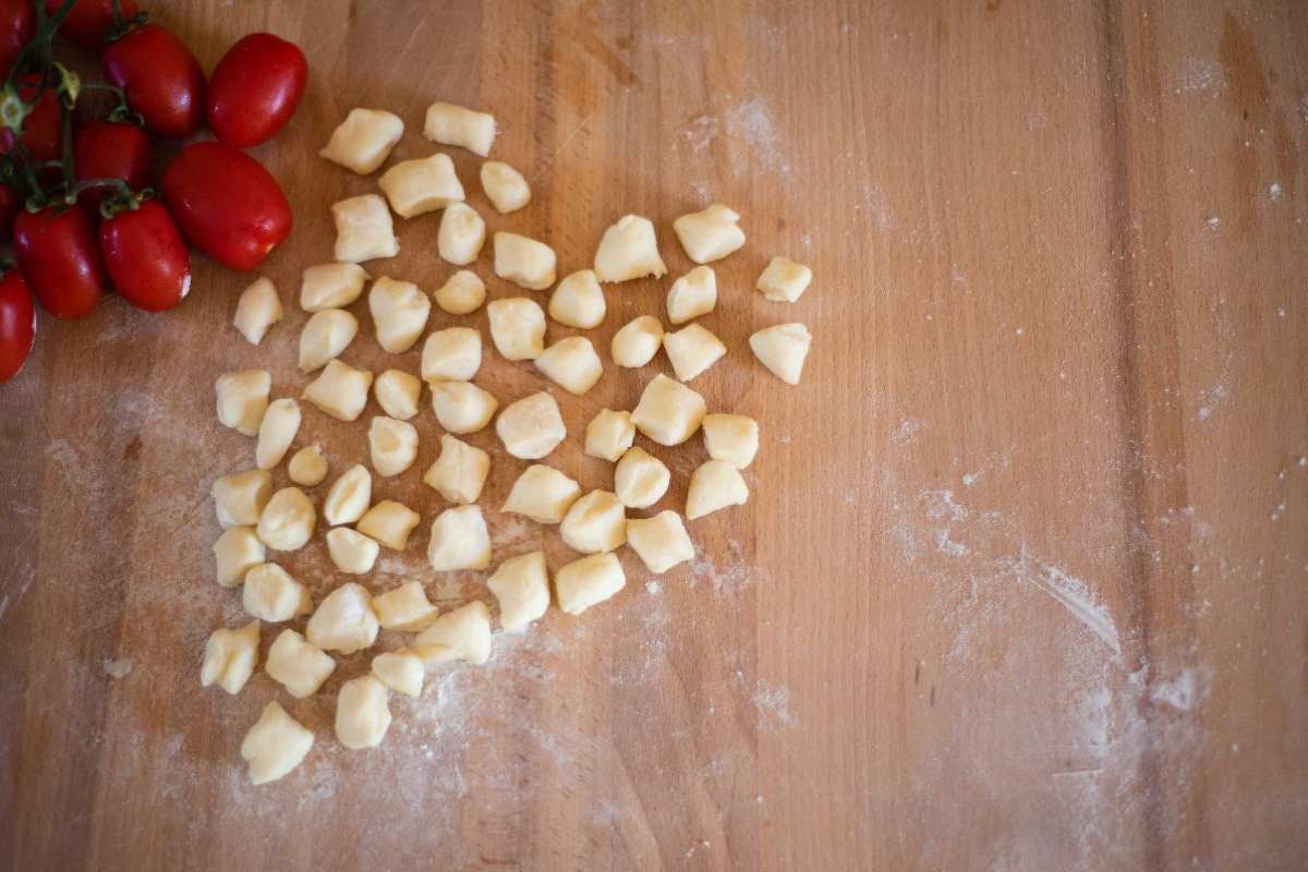 gnocchi freschi e pomodorini poggiati su un tagliere