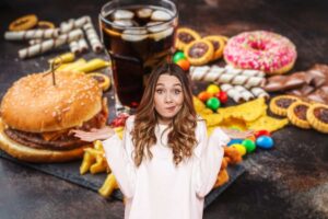 donna in primo piano indecisa se mangiare dei cibi dolci o dei cibi salati