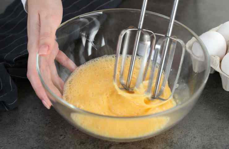 uova e zucchero in ciotola con mixer
